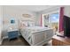 Cozy bedroom with white furniture, beach-themed decor and walk out to balcony at 4105 S Ocean Blvd. # 102, North Myrtle Beach, SC 29582