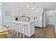 Bright kitchen featuring white cabinets, white appliances, bar seating and wood-look flooring at 4105 S Ocean Blvd. # 102, North Myrtle Beach, SC 29582