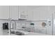 Bright kitchen featuring white cabinets, white appliances, and white subway tile backsplash at 4105 S Ocean Blvd. # 102, North Myrtle Beach, SC 29582