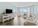 Bright living room with light colored furniture, wood floors and ocean view from sliding glass doors at 4105 S Ocean Blvd. # 102, North Myrtle Beach, SC 29582