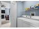Bright laundry room with modern washer and dryer, shelving and connections to the living room at 4162 Dupree Dr., Little River, SC 29566