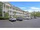 Three-story condo complex featuring balconies, white railings, and parking at 4221 Hibiscus Dr. # 8-203, Little River, SC 29566