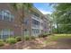Exterior view of a brick building with trees and grass in a community at 4221 Hibiscus Dr. # 8-203, Little River, SC 29566
