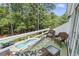 Balcony with outdoor seating overlooks the in-ground pool and lush trees at 4691 Mill Pond Rd., Murrells Inlet, SC 29576