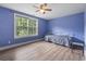 Bedroom with light-wood flooring and a ceiling fan features a large window and a small bed at 4691 Mill Pond Rd., Murrells Inlet, SC 29576