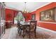 Elegant dining room features a chandelier, tile floors, and a decorative painting displayed on the red walls at 4691 Mill Pond Rd., Murrells Inlet, SC 29576