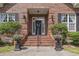 Charming brick front porch with decorative columns, manicured shrubs, and a welcoming front door with wreath detail at 4691 Mill Pond Rd., Murrells Inlet, SC 29576
