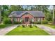Charming single-story brick home featuring a circular driveway and a beautifully landscaped front yard with a water feature at 4691 Mill Pond Rd., Murrells Inlet, SC 29576
