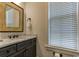 Modern bathroom features a decorative mirror, marble countertop and wooden cabinets at 4986 Salt Creek Ct., North Myrtle Beach, SC 29582