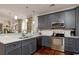 Beautiful kitchen with stainless steel appliances, gray cabinets, a sink, and hardwood flooring at 4986 Salt Creek Ct., North Myrtle Beach, SC 29582