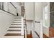 Bright interior shot of an elegant staircase featuring dark wood steps and white banisters at 4986 Salt Creek Ct., North Myrtle Beach, SC 29582