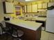 Bright eat-in kitchen featuring white cabinets and appliances and yellow walls with beach decor at 500 Fairway Village Dr. # 4-F, Myrtle Beach, SC 29588