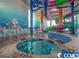 Indoor waterpark features a hot tub with slides and colorful aquatic-themed decor for Gathering fun at 5300 N Ocean Blvd. # 442, Myrtle Beach, SC 29577