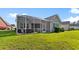 Backyard view showcasing a screened porch and well-maintained lawn at 5712 Whistling Duck Dr., North Myrtle Beach, SC 29582