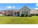 Backyard view featuring a screened porch and lush green lawn at 5712 Whistling Duck Dr., North Myrtle Beach, SC 29582