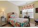 Cozy bedroom with floral bedding and a window dressed with striped valances at 5712 Whistling Duck Dr., North Myrtle Beach, SC 29582