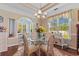 Charming dining area with a glass table, wicker chairs, elegant chandelier, and sunlit windows offering a cozy ambiance at 5712 Whistling Duck Dr., North Myrtle Beach, SC 29582