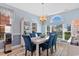 Bright dining room featuring blue chairs, a white table, decorative hutch, and large windows for ample natural light at 5712 Whistling Duck Dr., North Myrtle Beach, SC 29582