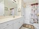 Bathroom showcasing a mirror above a white sink with palm tree wallpaper, bath, and shower at 601 Hillside Dr. N # 3926, North Myrtle Beach, SC 29582