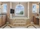 This bathroom features a soaking tub with steps, tile floors, and a large window with blinds at 664 Oxbow Dr., Myrtle Beach, SC 29579