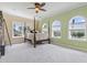 A large bedroom with pastel-painted walls, a four-poster bed, plush carpeting, and plenty of light at 664 Oxbow Dr., Myrtle Beach, SC 29579