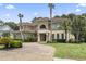 Stunning Mediterranean-style home with a tile roof, brick driveway, and lush landscaping at 664 Oxbow Dr., Myrtle Beach, SC 29579