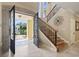 Welcoming foyer with a grand staircase, ironwork details, and abundant natural light at 664 Oxbow Dr., Myrtle Beach, SC 29579