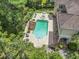 Aerial view of the backyard featuring a large pool, hot tub, and lounge area surrounded by trees at 664 Oxbow Dr., Myrtle Beach, SC 29579