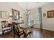 Elegant dining room with a glass table, chandelier, hardwood floors, and decorative blue curtains at 716 Weston Dr., Conway, SC 29526