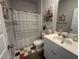 Bright bathroom featuring a white vanity, mirror, and a shower with a striped curtain for privacy at 8164 Forest Edge Dr., Myrtle Beach, SC 29579