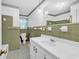 Clean bathroom with neutral tiled walls, patterned flooring, and a large mirror above the sink at 823 Bellamy Ave., Murrells Inlet, SC 29576