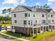 Attractive three-story townhome with a brick foundation, small balconies and a manicured lawn at 8468 Duke Pl. # 28, Myrtle Beach, SC 29572
