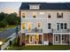 Cozy three-story townhome with a balcony, warm interior lights, and a peaceful ambiance at dusk at 8468 Duke Pl. # 28, Myrtle Beach, SC 29572