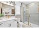 Modern bathroom with white marble vanity and glass enclosed shower with gold trim and hardware at 8470 Duke Pl. # 29, Myrtle Beach, SC 29572