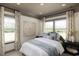 Bright bedroom featuring large windows, white and blue bedding, and stylish neutral decor at 8470 Duke Pl. # 29, Myrtle Beach, SC 29572