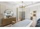 Spacious main bedroom with a view of the ensuite bathroom and a stylish dresser with round mirror at 8470 Duke Pl. # 29, Myrtle Beach, SC 29572