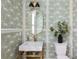 Chic powder room with floral wallpaper, brass fixtures, decorative mirror, and pedestal sink at 8470 Duke Pl. # 29, Myrtle Beach, SC 29572