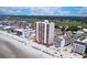 Aerial view shows a beachfront condo surrounded by beaches, trees, and nearby buildings at 912 N Waccamaw Dr. # 202, Garden City Beach, SC 29576