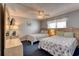 Bright bedroom features two twin beds with blue seashell bedding, a ceiling fan, and coastal decor at 912 N Waccamaw Dr. # 202, Garden City Beach, SC 29576