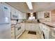 Well-lit kitchen equipped with white appliances, laminate countertops, and a separate laundry area at 912 N Waccamaw Dr. # 202, Garden City Beach, SC 29576