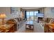 Cozy living room with plush seating and stunning ocean views from the balcony at 912 N Waccamaw Dr. # 202, Garden City Beach, SC 29576