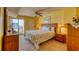 Bright bedroom with access to a private balcony overlooking the ocean, wood furnishings, and ceiling fan at 912 N Waccamaw Dr. # 202, Garden City Beach, SC 29576