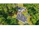 Aerial view of a home with a dark roof and a separate garage and shed area surrounded by dense trees at 938 Fox Hollow Rd., Conway, SC 29526