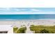 View of the sandy beach and oceanfront with dunes, beachgoers, and blue skies and water at 9755 Leyland Dr. # 2, Myrtle Beach, SC 29572