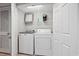 Laundry closet with a washer, dryer, and storage shelving at 1003 S Ocean Blvd. # 802, North Myrtle Beach, SC 29582