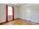 Dining room boasts hardwood floors, a classic chandelier, and a window dressed with red curtains at 1024 Palmetto St., Georgetown, SC 29440