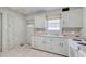 Kitchen with white cabinets, laminate floors, and a window above the sink at 1024 Palmetto St., Georgetown, SC 29440
