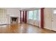 Spacious living room with hardwood floors, brick fireplace, and large windows providing ample natural light at 1024 Palmetto St., Georgetown, SC 29440
