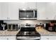 Kitchen area with a black range, stainless steel microwave, and granite countertops at 1074 Sennema Circle, Myrtle Beach, SC 29588