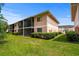 Two-story condo building featuring screened balconies, tidy landscaping, and green lawn under a blue sky at 1101 2Nd Ave. N # 1501, Surfside Beach, SC 29575